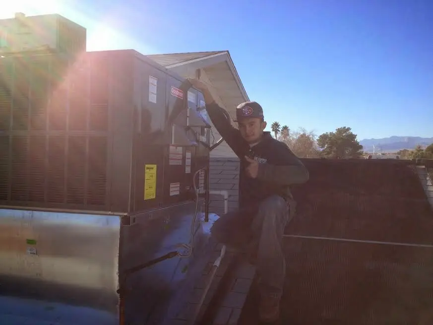 HVAC technician performing HVAC Inspection on a rooftop unit in Sycamore